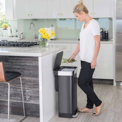 45L rectangular pedal bin with liner pocket - black finish - lifestyle woman throwing stems away