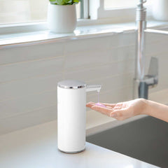 rechargeable liquid soap sensor pump - white finish - lifestyle with hand using pump in kitchen